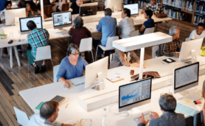 Personas utilizando computadores en una empresa educativa